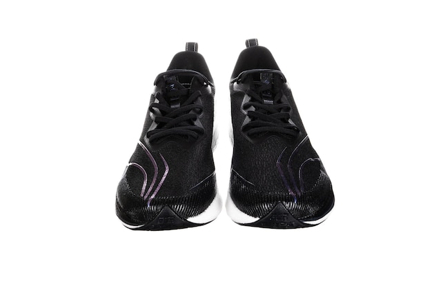 Foto paar nieuwe merkloze zwarte hardloopschoenen of sneakers geïsoleerd op een witte achtergrond met uitknippad