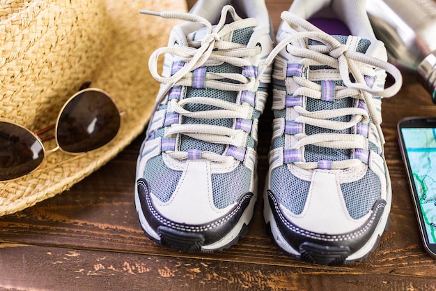 Paar nieuwe wandelschoenen voor dames met topokaart op een houten ondergrond.