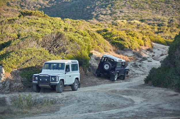 Paar off-road voertuigen op een geparkeerd onverhard pad symbool van excursie in desolaat