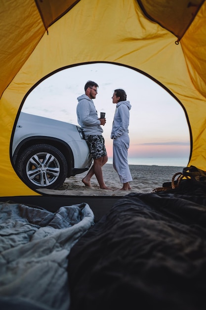 Paar ontmoeten zonsopgang op zee strand uitzicht door camping tent zomervakantie