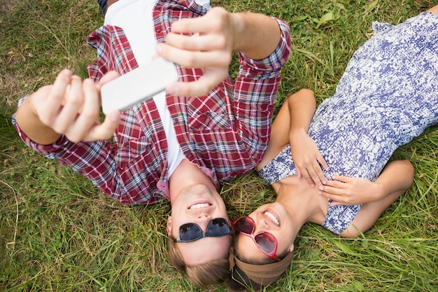 Paar ontspannen in het park selfie te nemen