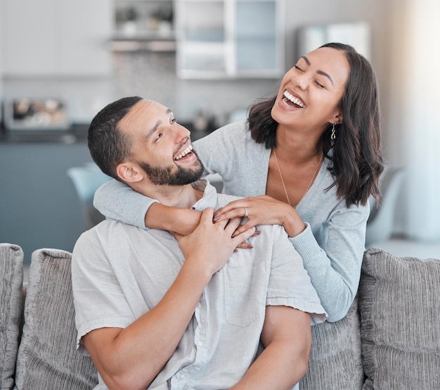 Paar ontspannen op de bank lachen en glimlachen samen met liefdesondersteuning en knuffelpartner in de woonkamer van een modern appartement thuis Zwarte vrouw gelukkige man en vrede in de lounge met wellnessbinding op een bank