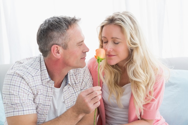 Paar ontspannen op de bank met meisje ruikende bloem