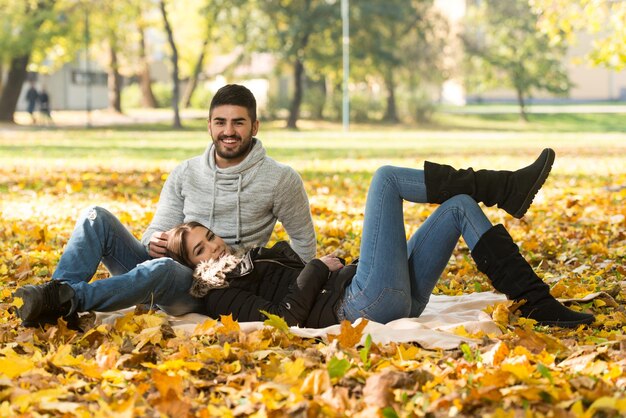 Paar ontspannen op deken in herfstpark