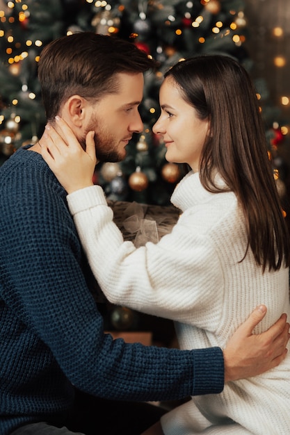 Paar op zoek naar elkaar en knuffelen. kerstboom