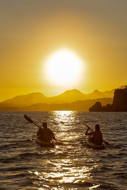 Paar peddelen met een zeekajak op de Middellandse Zee bij zonsondergang Altea, Spanje stock foto