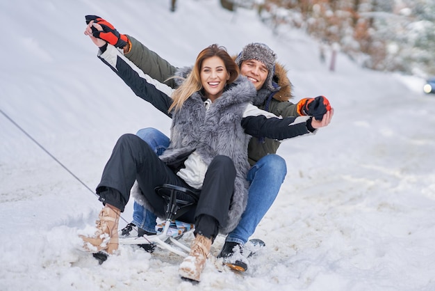 Paar plezier met slee op sneeuw in de wintersneeuw. Hoge kwaliteit foto