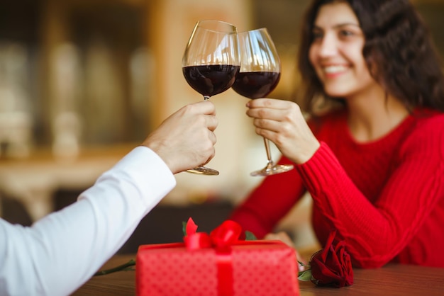 Paar rammelglazen met rode wijn Liefhebbers geven elkaar cadeaus Heerlijk romantisch diner