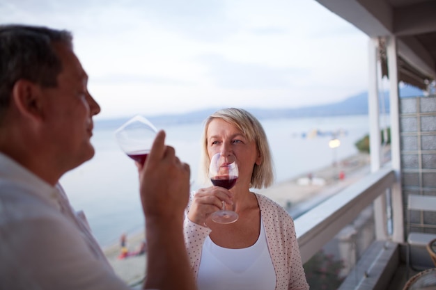 Paar rode wijn drinken op balkon van strandhotel
