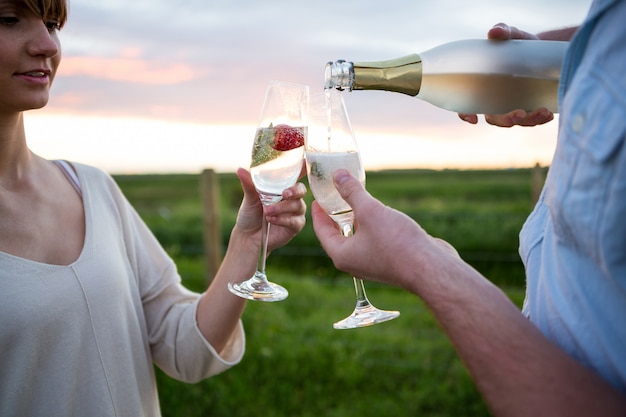 Paar roosterende champagne in veld