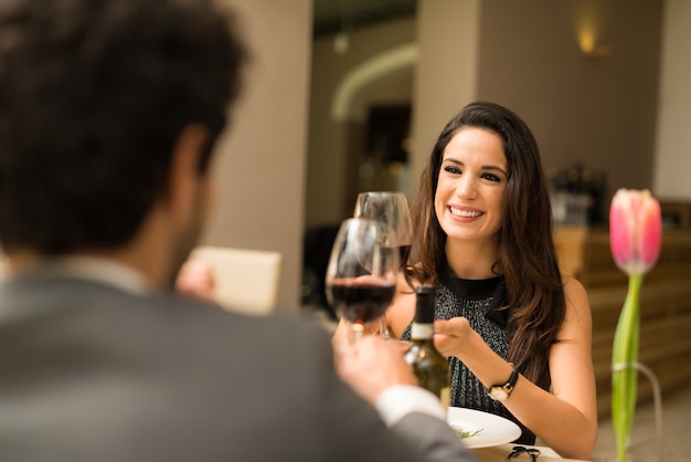 Paar roosterende wijnglazen in een luxerestaurant. Focus op de vrouw