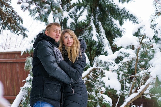 Paar rust in winter bos meisje blonde Europese vrouw knuffelt haar man in gebreide wanten en wa...