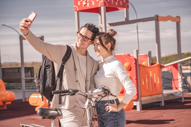 Paar rusten na het fietsen selfie te nemen met mobiele telefoon