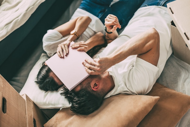 Paar rusten op de vloer op de dag dat ze naar een nieuw appartement verhuizen