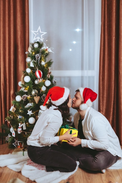 Paar schieten voor versierde kerstboom