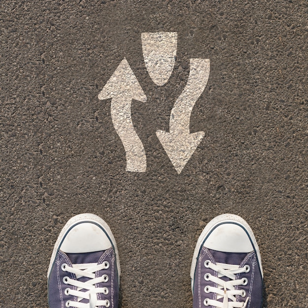 Foto paar schoenen die zich op een weg met verkeersteken bevinden