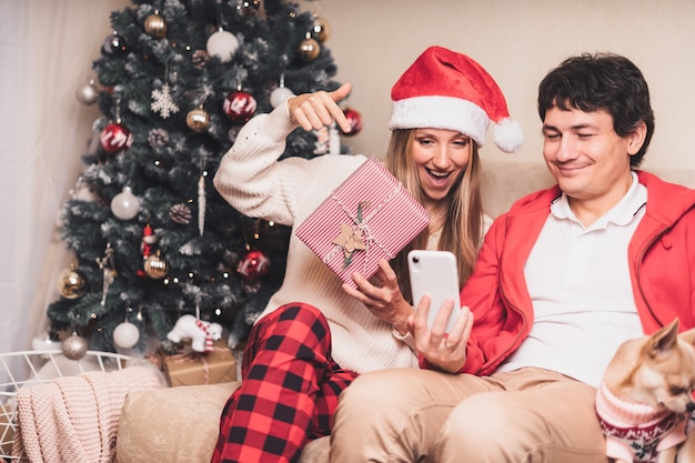 Paar schuren kerstgroeten met hun smartphone