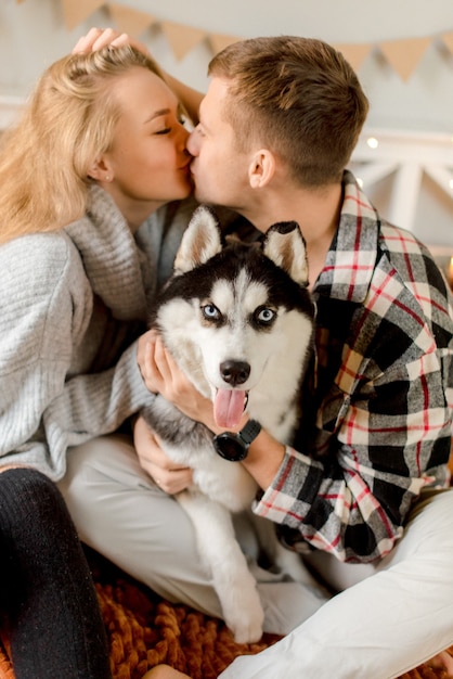 Foto paar spelen met hond in slaapkamer