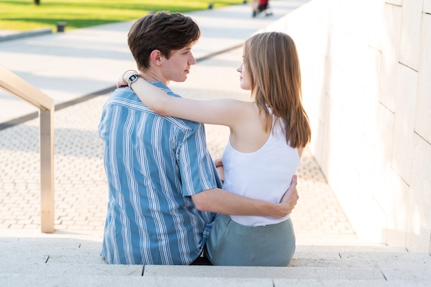 Paar tieners hand in hand en knuffelen in het park De eerste liefde