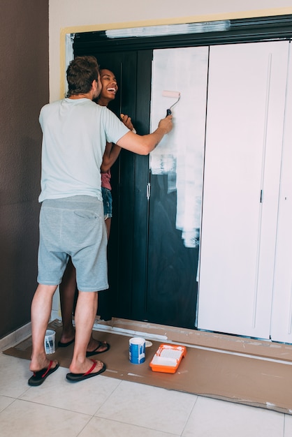 Paar tussen verschillende rassen die een garderobe schilderen