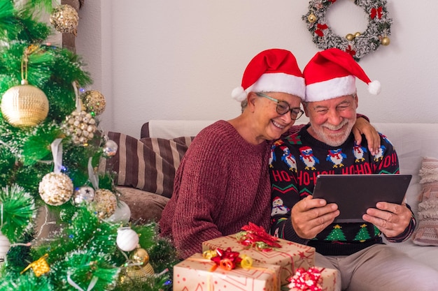 Paar twee senioren videobellen met hun familie thuis vieren kerst met laptop