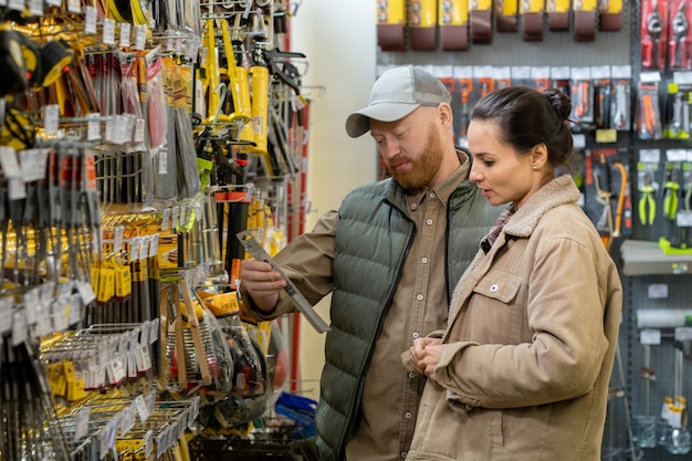 Paar van middelbare leeftijd dat handgereedschap kiest in grote hardware-supermarkt