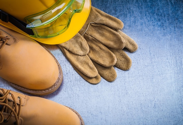 Paar veiligheidsveterlaarzen leren handschoenen veiligheidshelm en transparanten