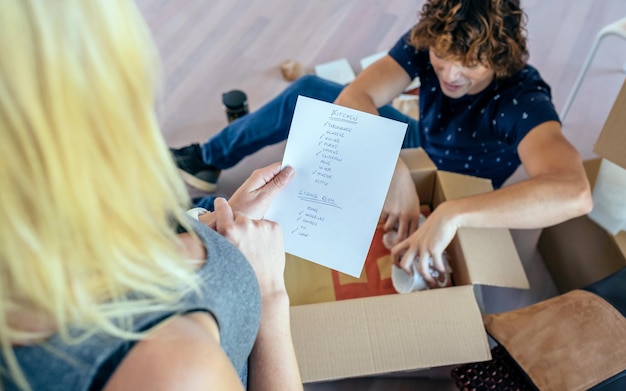 Foto paar verhuisdozen uitpakken in hun nieuwe huis