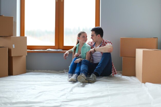 Paar verhuizen in huis zittend op de vloer Couple