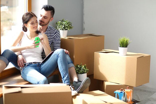 Paar verhuizen in huis zittend op de vloer Couple