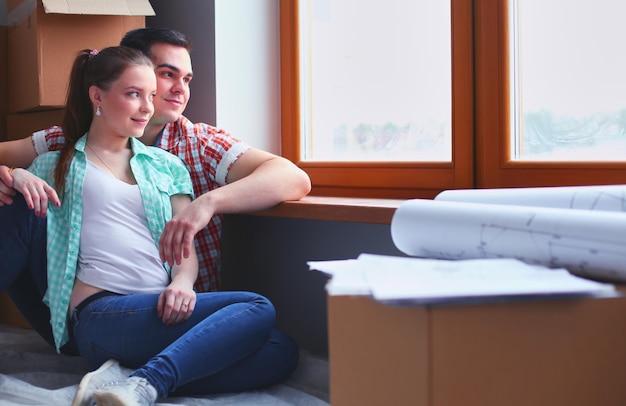 Paar verhuizen in huis zittend op de vloer Couple