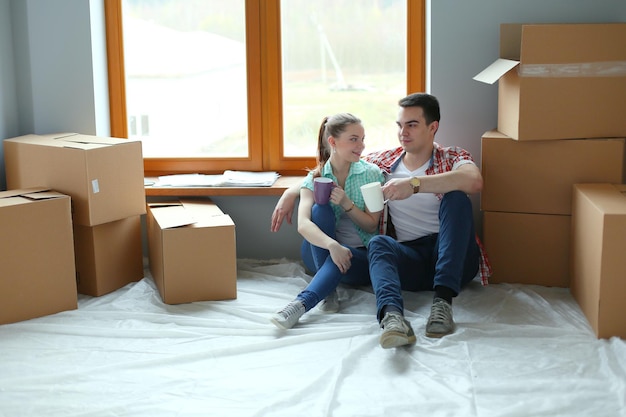 Paar verhuizen in huis zittend op de vloer