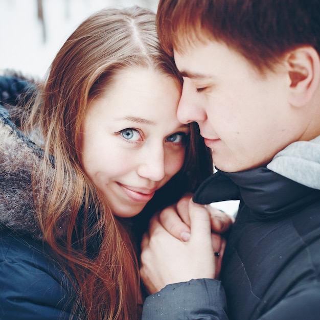 Paar verliefd knuffelen en plezier in winter woud