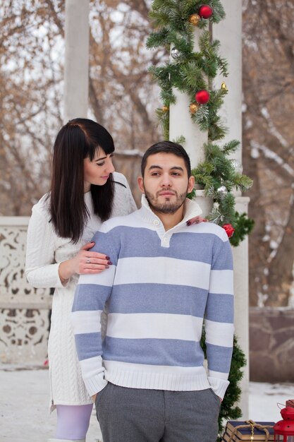 Paar verliefd knuffelen in kerst versierd prieel