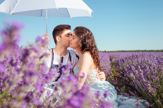 paar verliefd onder een paraplu op een lavendelveld