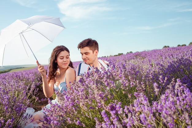 Paar verliefd onder een witte paraplu op een lavendelveld