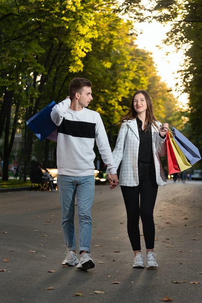 Paar verliefd op boodschappentassen loopt in park hand in hand