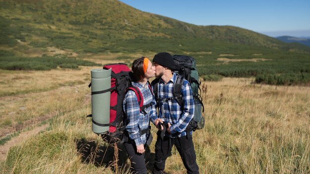 Paar verliefd toeristen man en vrouw staan op een berg vlakte hartstochtelijk kussen