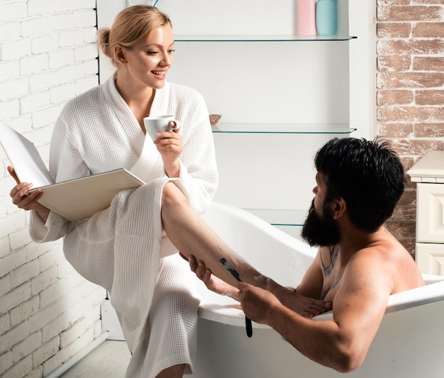 Foto paar verliefd verzorgen in de ochtend knappe bebaarde man wassen in bad gelukkige jonge paar in bathro