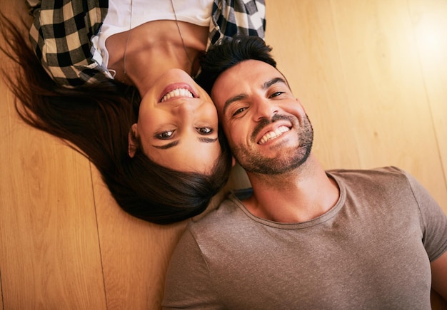 Paar vloer en portret voor ontspanning in huis woonkamer en grond van nieuw huis onroerend goed investering aankoop en top uitzicht van opgewonden man en vrouw persoon getrouwd en hypotheek of vastgoed