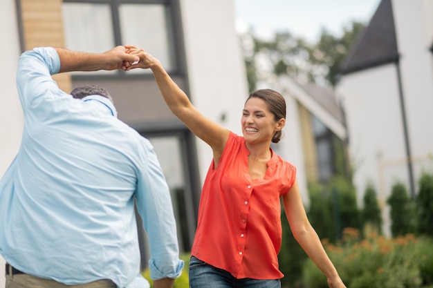 Paar voelt zich geweldig. Vrolijk stralend stel voelt zich geweldig tijdens het dansen in de buurt van huis