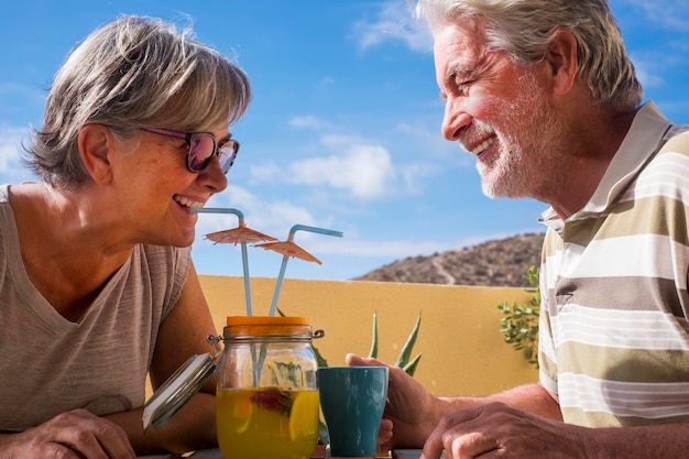 Paar volwassen senior in openlucht vrijetijdsbesteding drinken een vers sap van fruit op het terras samen vrolijke mensen oud leven voor altijd familie en relatie concept voor gepensioneerde man en vrouw