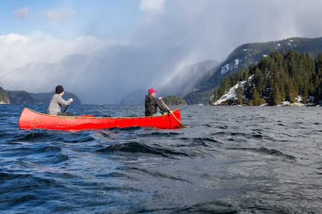 Foto paar vrienden op een houten kano door canadese bergen