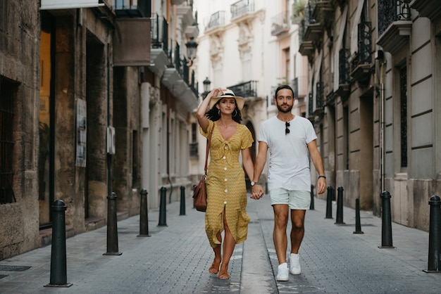 paar wandelen met elkaars hand in de oude stad van Spanje. Een paar toeristen op date in Valencia.