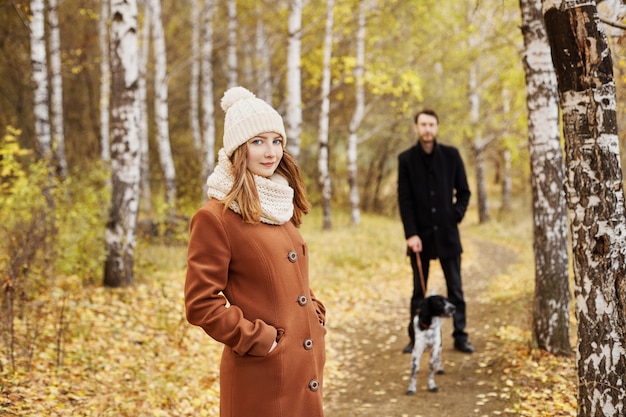 Paar wandelen met hond in het park en knuffelen. Herfstwandeling