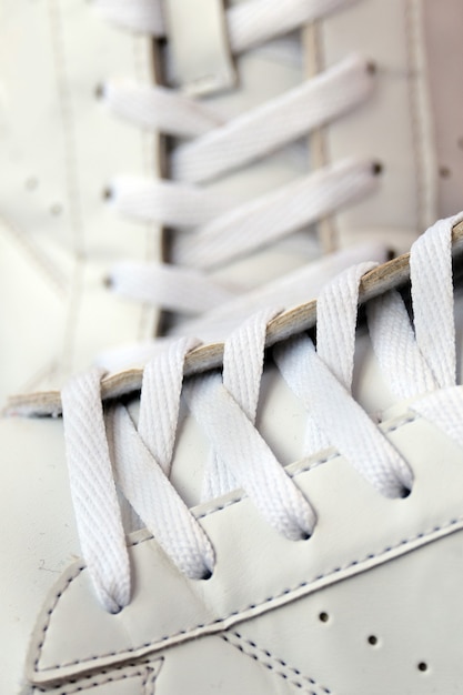 Paar witte gebruikte sneakers met schoenveters close-up