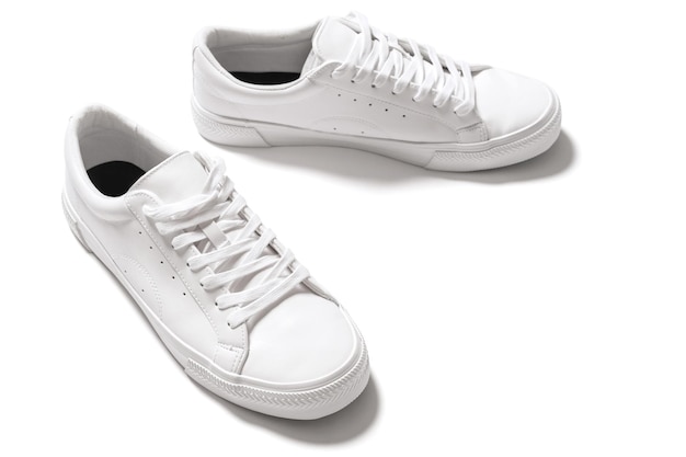 Paar witte leren sneakers met een schaduw op een witte achtergrond