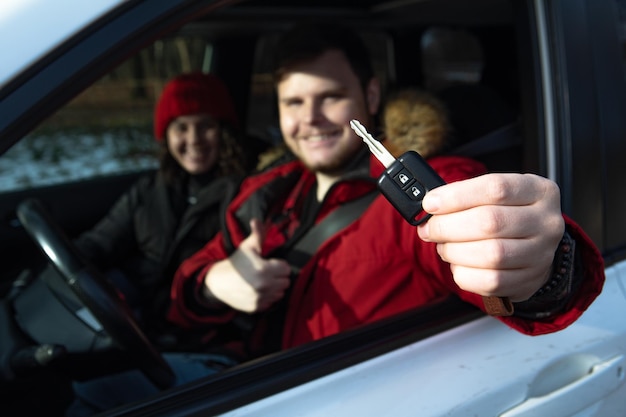 Paar zitten in auto man met autosleutel in de hand