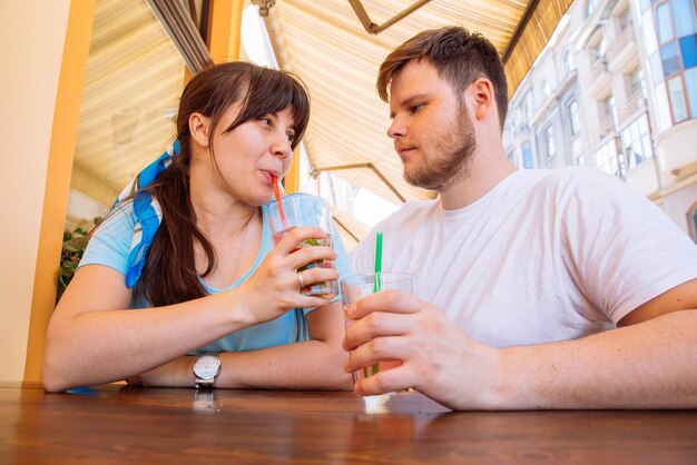 Paar zitten in zomercafé koele drankjes drinken en praten