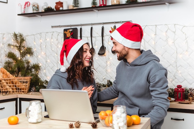 Paar zitten keuken gebruik laptop cadeaus kopen Internet slingers thuis gezellige interieur sfeer